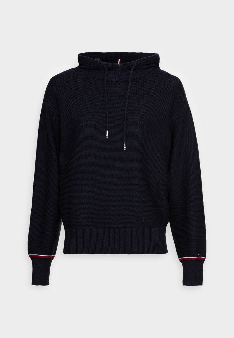 Sweat à capuche noir en tricot à manches longues avec cordons de serrage et poignets côtelés présentant un détail de fine bande rouge et blanche sur chaque poignet.