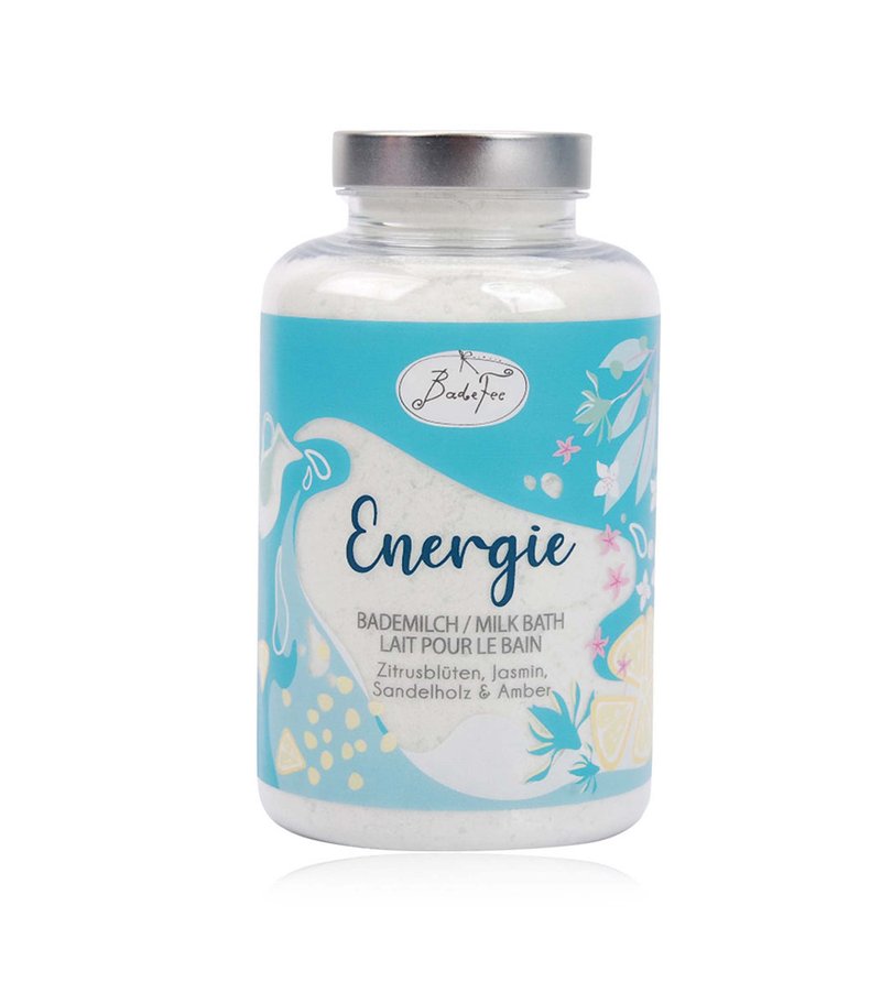 Milk bath powder labeled "Energie" with citrus, jasmine, sandalwood, and amber scents in a clear jar with a blue floral design.