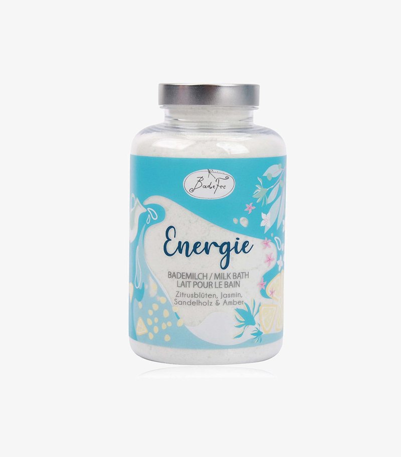 Milk bath powder labeled "Energie" with citrus, jasmine, sandalwood, and amber scents in a clear jar with a blue floral design.