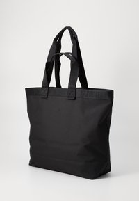 Borsa a tote in tessuto nero con due paia di manici, caratterizzata da una discreta stampa in rilievo sul bordo superiore e sui manici.