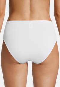 Weiße Baumwollslips mit nahtlosem Design. Weiche, glatte Textur, mit mittelhohem Bund und vollständiger Abdeckung auf der Rückseite. Keine sichtbaren Nähte.