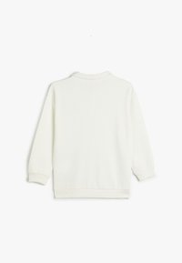 Valkoinen ribbineulepullover, jossa on pyöreä kaula-aukko, pitkät hihat ja ribbineulosrivit. Tasainen pinta kauttaaltaan ilman näkyviä saumoja tai kuvioita.