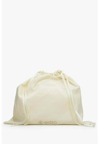 Katoenen trekkoordzak in crèmekleur met contrasterende witte linten, voorzien van een subtiel logo onderaan en een zachte textuur.