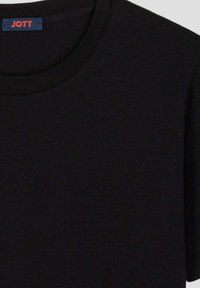 T-shirt in cotone nero con scollatura rotonda classica. Presenta un piccolo etichetta logo rosso "JOTT" sul collo. Texture morbida, design semplice.
