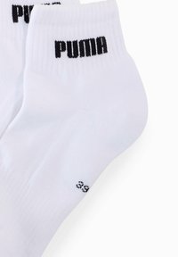 Białe skarpetki z bawełny z domieszką, z prążkowanymi ściągaczami, z czarnym logo "PUMA" oraz małym oznaczeniem rozmiaru nadrukowanym na boku.
