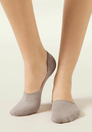 Calzini no-show grigio chiaro realizzati in materiale morbido, caratterizzati da un design senza cuciture e uno stile a taglio basso che lascia scoperta la caviglia.