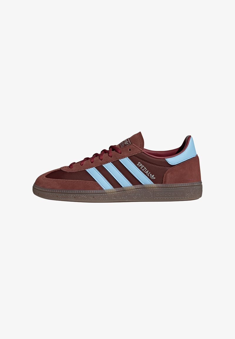 Baskets en daim marron avec des bandes Adidas bleu clair, bout arrondi, fermeture à lacets, semelle texturée et logo embossé sur la languette.