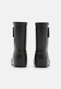 Bottes en caoutchouc noires à finition lisse, hauteur mi-mollet, forme arrondie et semelle texturée, dotées de sangles ajustables sur les côtés.