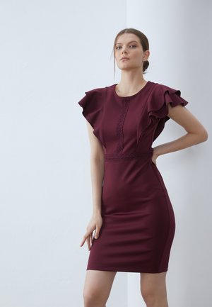 Burgundy klänning med volangiga korta ärmar, åtsittande design, dekorativ söm längs framsidan och slät textur.