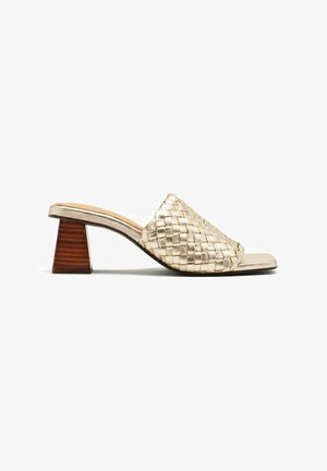 Chaussure à glissière tissée en or métallique avec un bout carré et un talon bloc en bois de hauteur moyenne. Présente un dessus tissé texturé pour plus de détails.