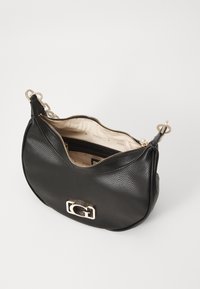 Borsa a mano in pelle nera con finitura testurizzata, accessori in oro e chiusura con zip. Presenta una tasca interna e un accento con logo sulla parte anteriore.