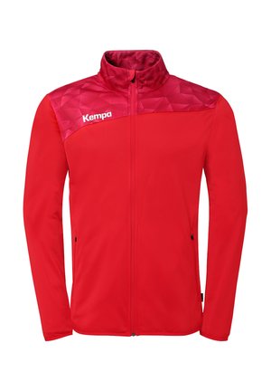 Veste rouge à fermeture éclair complète avec panneau supérieur de poitrine à motifs, col montant, poches latérales zippées et logo blanc "Kempa" sur la poitrine gauche.