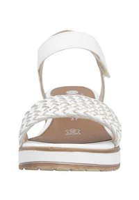 Sandales en cuir tressé blanc avec une semelle blanche et brune, présentant un bout fermé, une sangle de cheville et un léger talon.