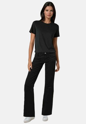 Zwarte katoenen t-shirt met korte mouwen, gecombineerd met zwarte flared jeans. De outfit heeft een eenvoudig ontwerp en een gladde textuur.