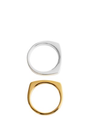 To minimalistiske ringe med fladt top, én i sølv og én i guld, vist vertikalt på en hvid baggrund.