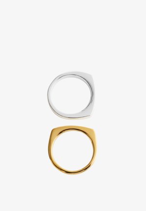 To minimalistiske ringe med fladt top, én i sølv og én i guld, vist vertikalt på en hvid baggrund.
