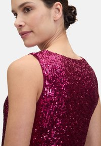 Fuchsia paillettenjurk met een mouwloos ontwerp, met ingewikkelde, reflecterende details en een gladde textuur op het lijfje.