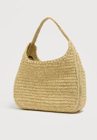 Τσάντα από πλεγμένο άχυρο σε ανοιχτό κίτρινο. Ημιδομημένο σχήμα με μια λαβή και ανοιχτό πάνω μέρος. Ομαλή υφή και στρογγυλεμένες άκρες.