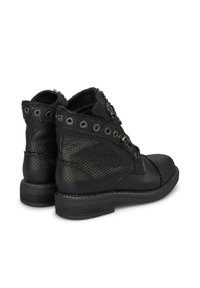 Botas de tobillo negras con un patrón de reptil texturizado, ojetes de metal, herrajes decorativos y puntera redonda con un tacón bajo.