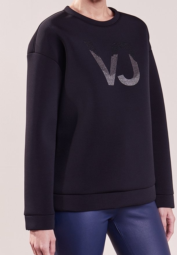 Sweatshirt noir avec un col rond, présentant un logo texturé en argent "VJ". Tissu doux, coutures d'épaule arrondies et poignets côtelés.