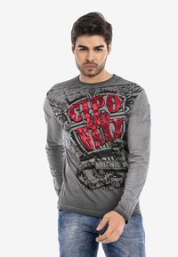 Graues Langarm-T-Shirt mit ausgefallenem roten und schwarzen Grafikdruck, der den Schriftzug "CIPO and BAXX" zeigt. Weicher Stoff mit Rundhalsausschnitt.
