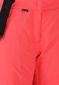 Koraal waterdichte shorts met een gladde textuur, verstelbare tailleband en een prominent merklabel aan de voorkant.