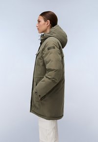 Parka impermeabile verde oliva con cappuccio, tasche laterali e chiusura con zip. Caratterizzata da una finitura testurizzata e una toppa con logo sulla manica.