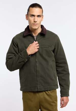 Green canvas jacket with a brown corduroy collar, front zipper, and side pockets. The fabric appears textured and durable.