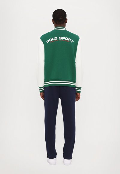 Zelená a bílá varsity bunda s výšivkou "POLO SPORT", v kombinaci s námořnickými tepláky a bílými teniskami. Jednoduchý a sportovní design.