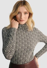 Szary golf z białym wzorem w zygzak. Długie rękawy, dopasowany krój, miękka tekstura i wysoki kołnierz.