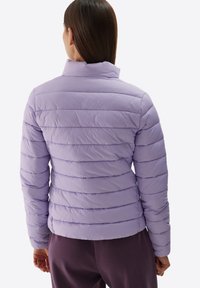 Giacca a vento viola chiaro con design a righe, colletto alto e polsini elasticizzati. Texture liscia con dettagli di cucitura orizzontale.
