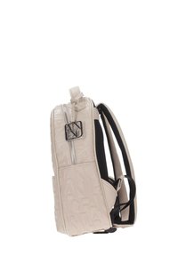 Zaino beige Armani Exchange con motivo a logo in rilievo, zip argentata, etichetta del marchio e spallacci neri imbottiti, visto di lato.