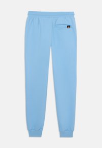 Blå joggebukser laget av mykt stoff, med elastisk midje, avsmalnede ankler og en liten sidelomme med logo-detalj.