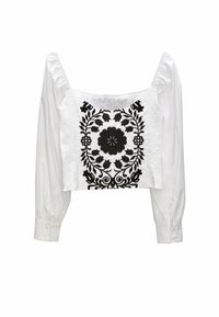 Hvid kort bluse med lange pufærmer, der har sort blomsterbroderi foran og strukturerede detaljer langs siderne.