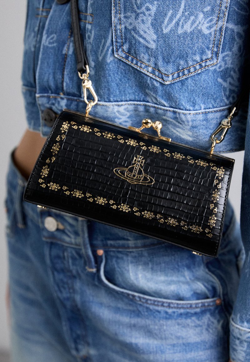 Black patent leather bag with a crocodile texture, gold floral accents, and a graphic logo. Features a clasp closure and detachable shoulder strap.