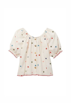 Blouse écrue à manches courtes bouffantes avec petits imprimés floraux multicolores, boutons devant et bordure festonnée rouge aux manches et à l'ourlet.