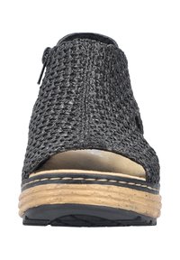 Sandały z otwartym palcem wykonane z plecionej czarnej tkaniny. Posiadają grube, brązowo-czarne podeszwy z widocznym szwem oraz zamek błyskawiczny z boku.