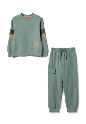 Conjunto de sudadera verde y pantalones joggers a juego, hechos de tela suave. La sudadera tiene acentos a rayas y el texto "WANDER LIFE". Los pantalones cuentan con un bolsillo lateral.