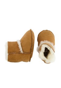 Tan suède laarzen met witte faux fur voering, korte hoogte en gestikte randen. Rond toe en zachte textuur; ontworpen voor warmte en comfort.