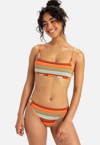 Randig bikiniuppsättning i orange, grön och ljusblå. Toppen har en rektangulär design med tunna axelband; botten har en låg midja.
