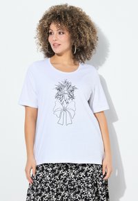 Camiseta blanca de algodón con una ilustración de contorno negro de un pájaro que lleva un lazo. Combinada con una falda negra con patrones de lazos blancos.
