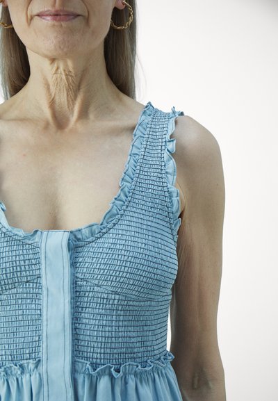 Rochie albastră cu părți din smock, bretele volan și fustă evazată. Prezintă un material texturat și un design cu nasturi în față, având o strălucire subtilă.