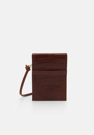 Brun taske i kunstlæder med krokodillepræg med en rektangulær form, slankt design, justerbar rem og en forlomme. Glat tekstur med prægede mønstre.