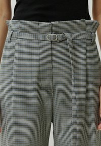 Blocks gestreepte broek in blauw en wit, met een hoge taille, riemlussen en een stoffen riem. Geplooide voorkant met zijzakken.