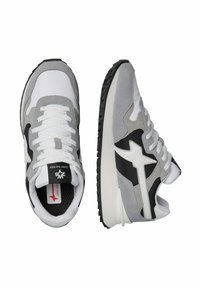 Sneaker atletici grigie e bianche con una miscela di suede e rete, accenti neri, suole spesse e lacci testurizzati. Logo a stella ben visibile sul lato.