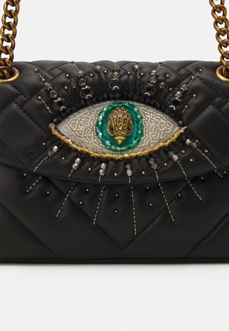 Borsa a tracolla in pelle trapuntata nera con un intricato design a forma di occhio, decorata con perline, accenti metallici e tracolla a catena. Decorazioni testurizzate e dettagliate.
