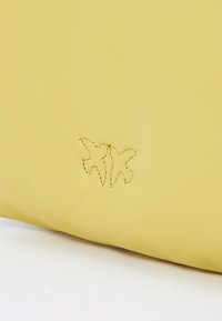 Borsa in pelle gialla con una texture liscia, caratterizzata da un design impresso di due farfalle cucite con filo dorato.