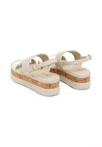 Sandali platform bianchi con base in sughero, dotati di cinturini larghi e dettaglio con fibbia. La suola è texturizzata per garantire aderenza e stabilità.
