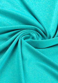 Tela turquesa con un patrón de espiga texturizado y un suave brillo, dispuesta en suaves pliegues, mostrando su suavidad y flexibilidad.