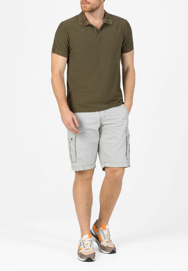 Olive green striped polo shirt with three buttons. Light gray cargo shorts with pockets. Casual gray and orange sneakers.